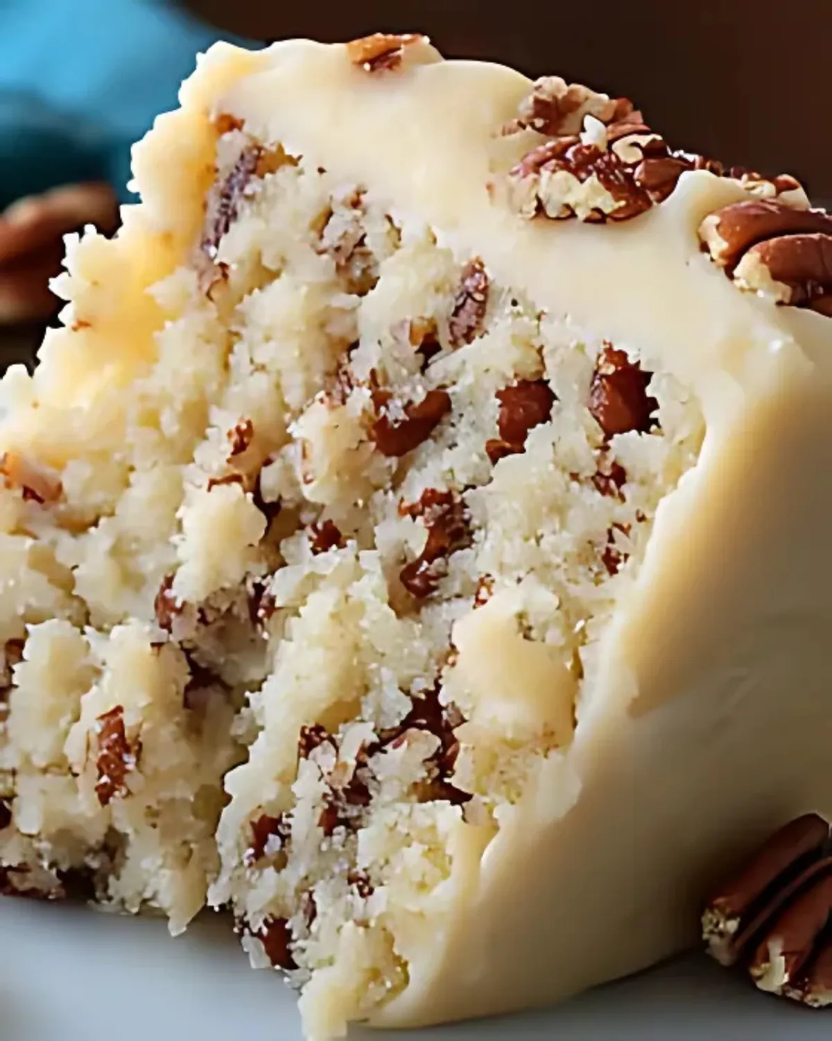 Moist butter pecan cake slice with creamy frosting and chopped pecans, showcasing rich texture and golden brown crumb.