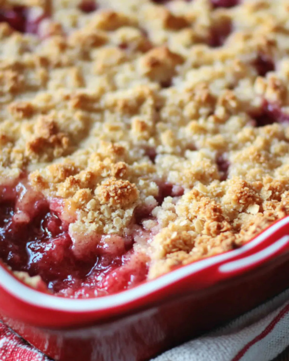 Freshly baked strawberry rhubarb crumble with golden streusel topping in a ceramic dish