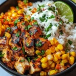 Close-up of grilled chicken and corn with cilantro lime cream over rice in a bowl