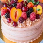 Whole summer sangria cake topped with cherries, raspberries, blackberries, and sliced peaches