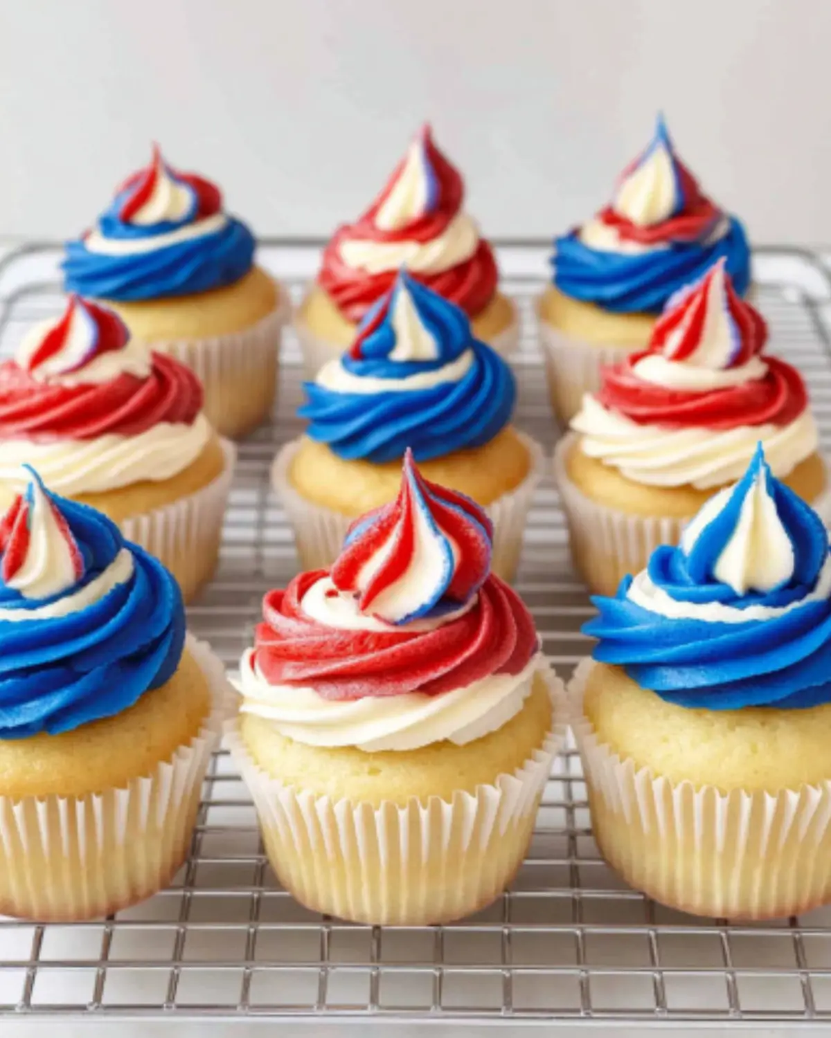 4th of July vanilla cupcakes with patriotic buttercream swirl and text overlay