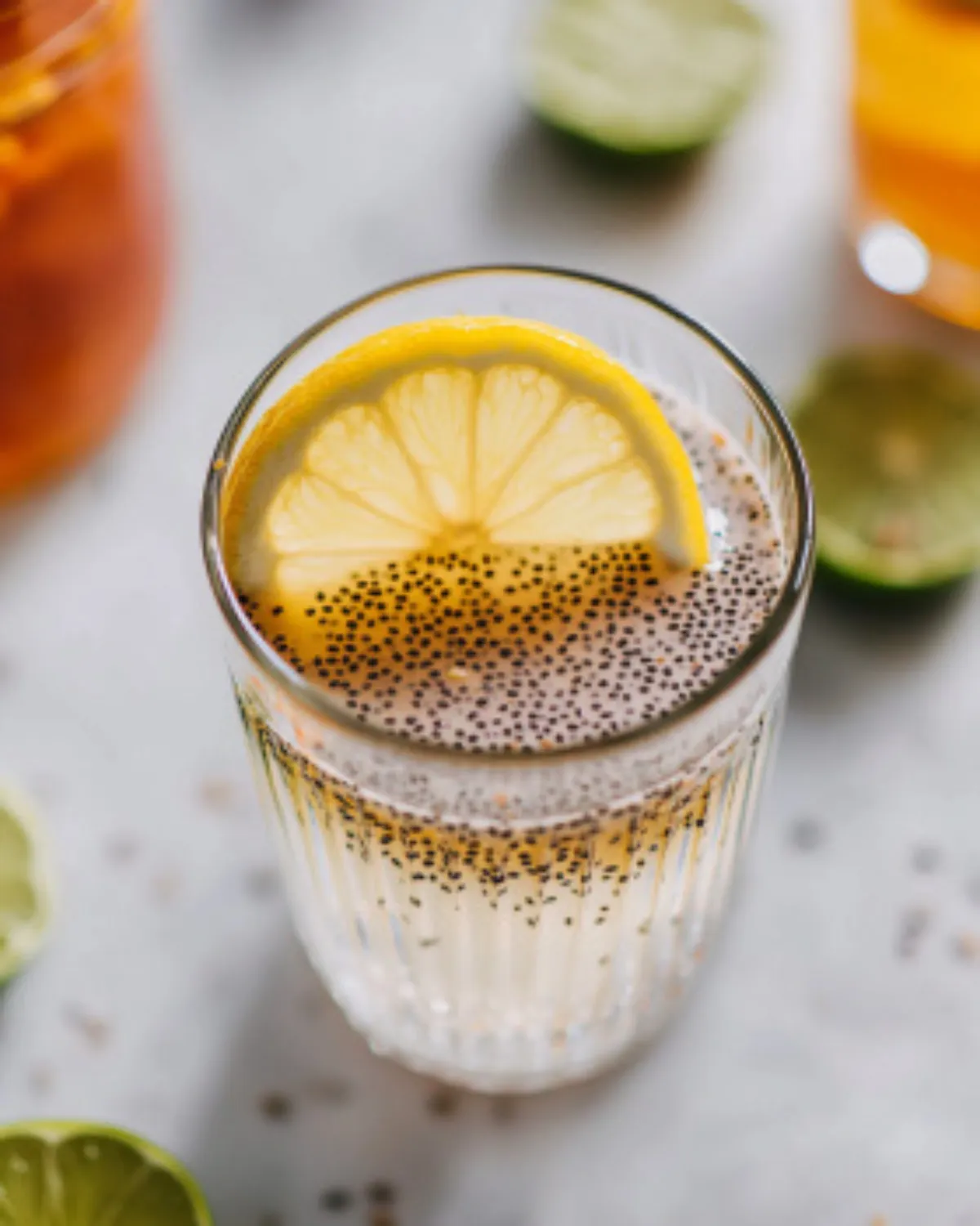 Close-up of lemon chia seed water in a tall ribbed glass on marble surface