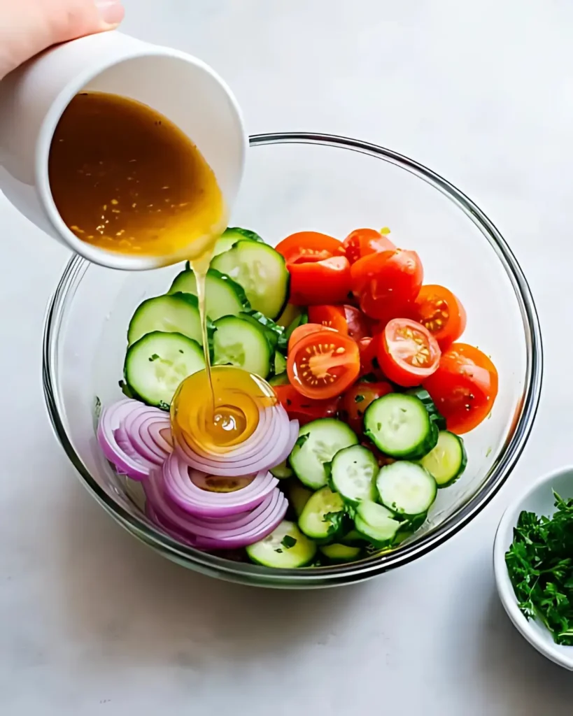 Pouring Vinaigrette Dressing Over Fresh Cucumber Tomato Salad