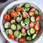 Fresh Cucumber Tomato Salad with Red Onion and Herbs in White Bowl