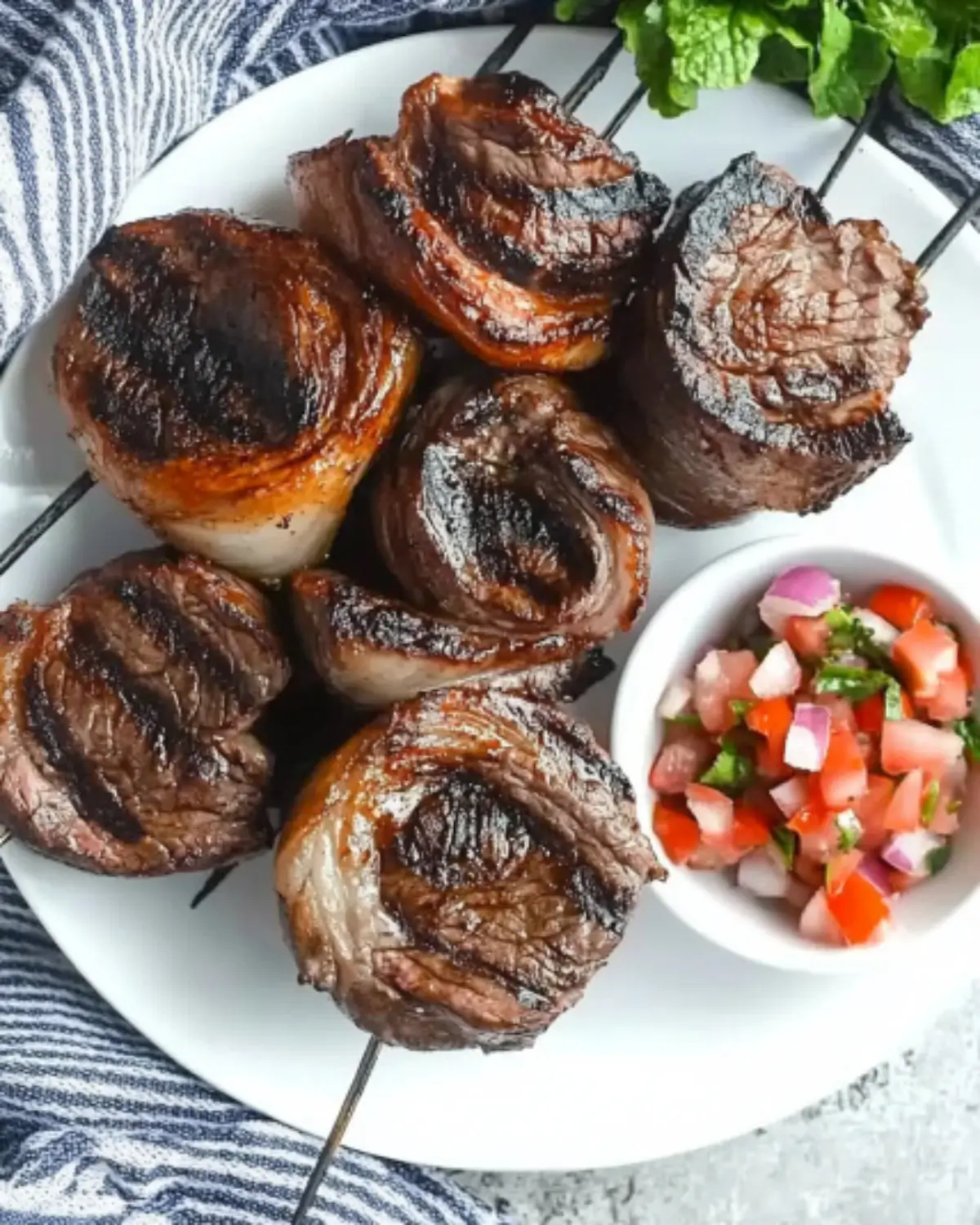 Char-grilled Brazilian picanha steaks on skewers with salsa on the side