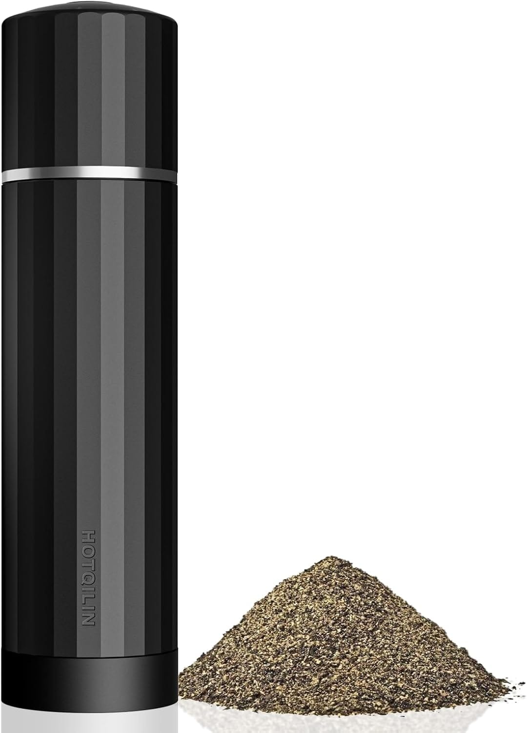 A sleek, black HOTALIN pepper grinder standing next to a mound of freshly ground black pepper.