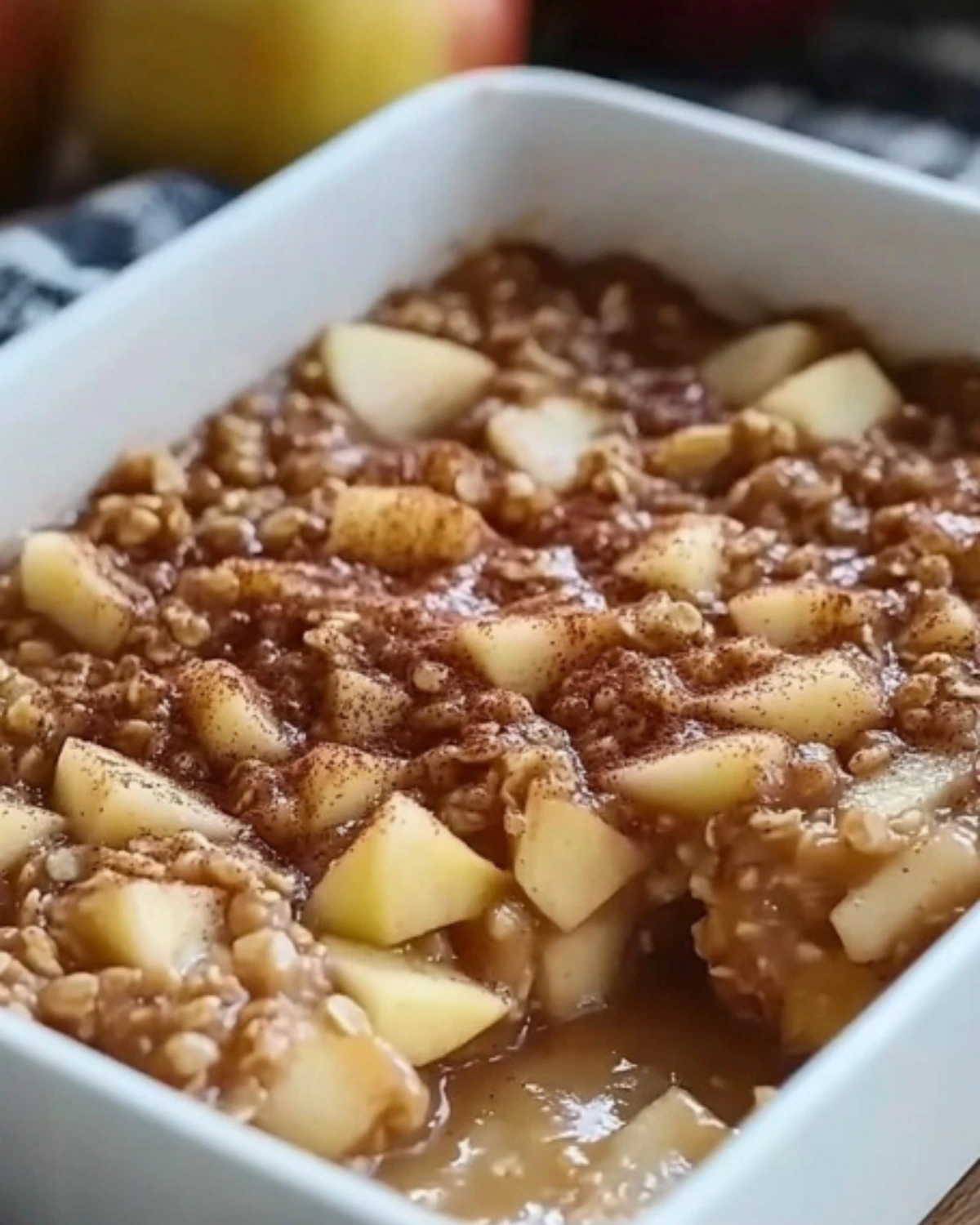 Apple cinnamon baked oatmeal topped with cinnamon sugar in a white baking dish