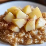 Creamy baked oatmeal topped with fresh apple chunks and cinnamon