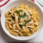 Bowl of creamy garlic parmesan chicken pasta topped with parsley and parmesan