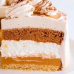 Layered pumpkin spice cake with whipped cream topping and visible pumpkin, frosting, and gingerbread layers.
