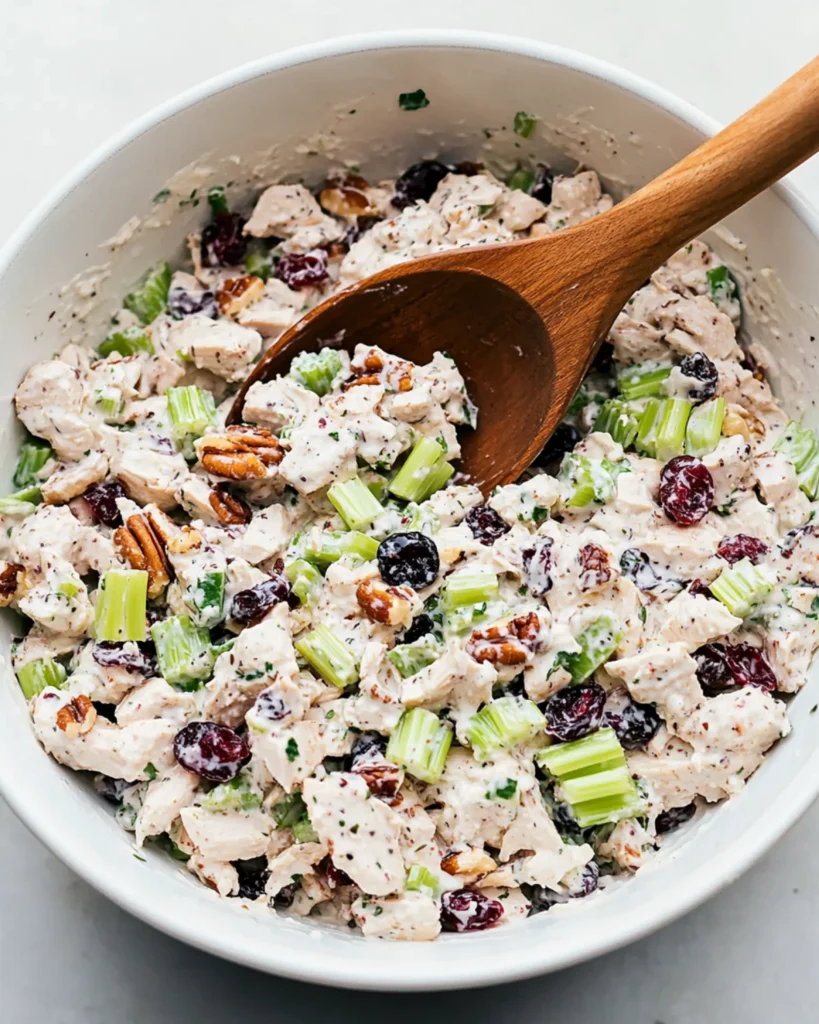 Bowl of homemade chicken salad with cranberries, celery, and pecans.