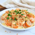 Baked sliced carrots with crispy breadcrumb topping and melted cheese garnished with fresh parsley.