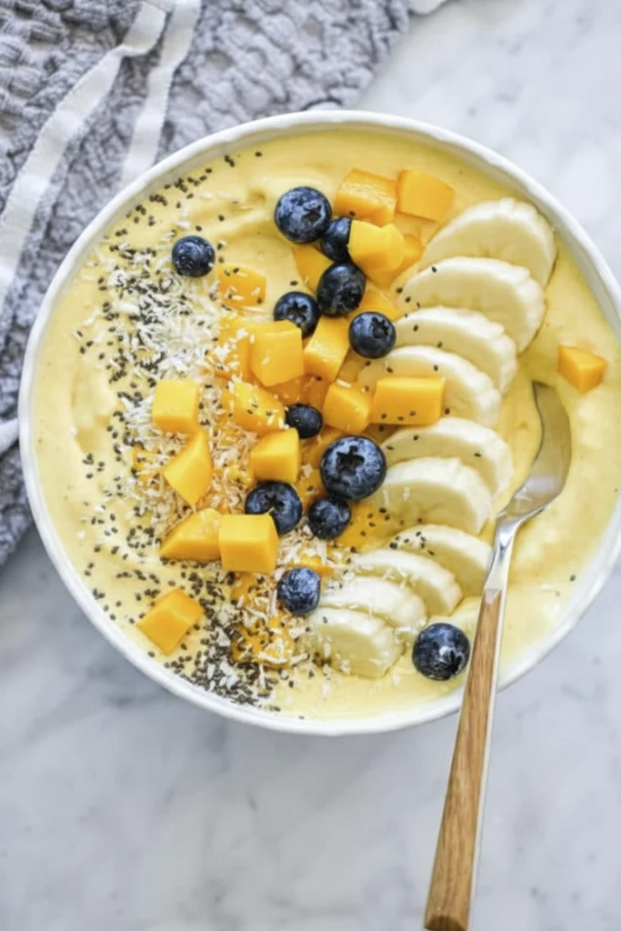 Clean eating smoothie bowl with fresh fruits and superfood toppings in white bowl