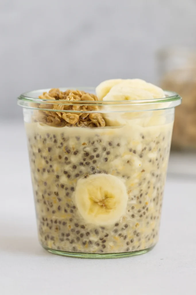 Caramel apple puff pastry tart with sliced apples on a white decorative plate and whole apples in the background.