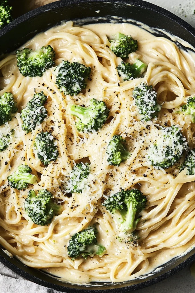 Creamy broccoli alfredo pasta with spaghetti and garlic parmesan sauce in a skillet.