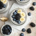 Top-down view of chia seed pudding topped with blueberries, blackberries, and banana slices.