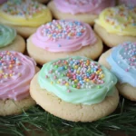 Pastel frosted sugar cookies topped with colorful sprinkles arranged closely together for an Easter dessert display.